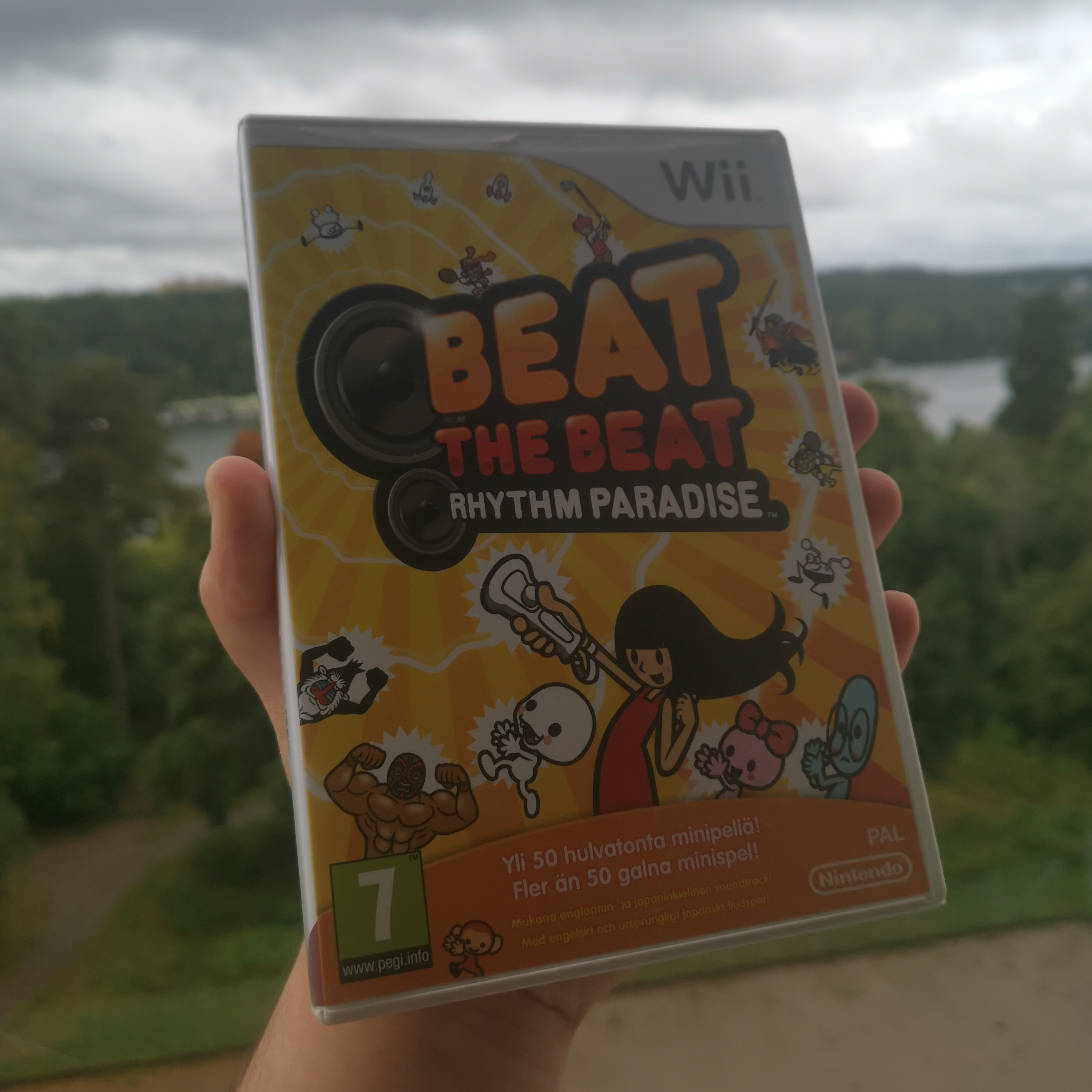 me holding my copy of beat the beat rhythm paradise on my balcony